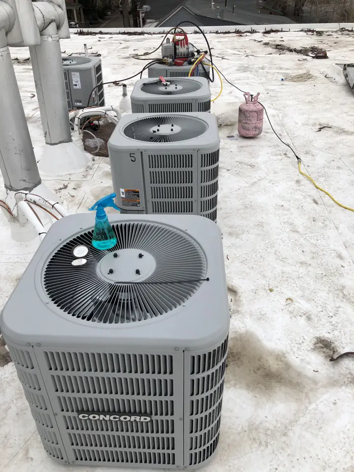 Row of rooftop condensers on a snowy commercial flat roof, a job by I Know A Guy HVAC in the Salt Lake Valley