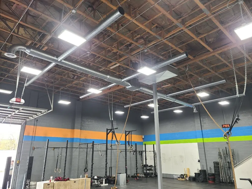 Exposed spiral ductwork installed overhead in a commercial gym, a job by I Know A Guy HVAC in the Salt Lake Valley