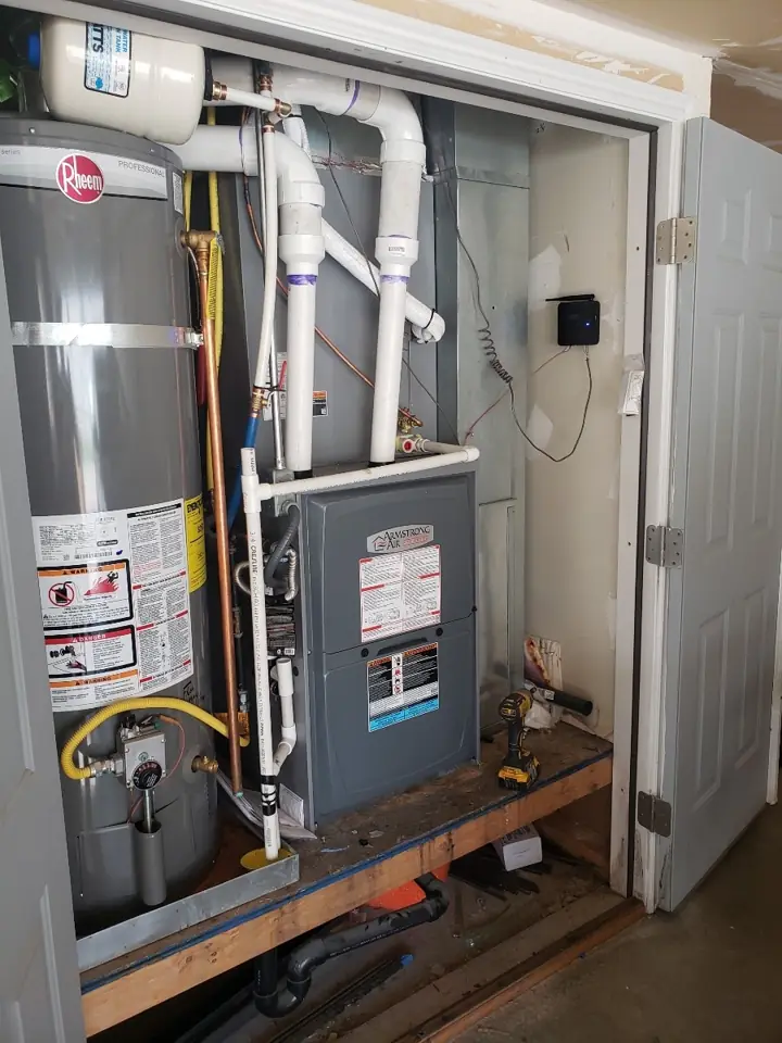 Tank water heater installed next to a furnace in a utility closet, a job by I Know A Guy HVAC in the Salt Lake Valley